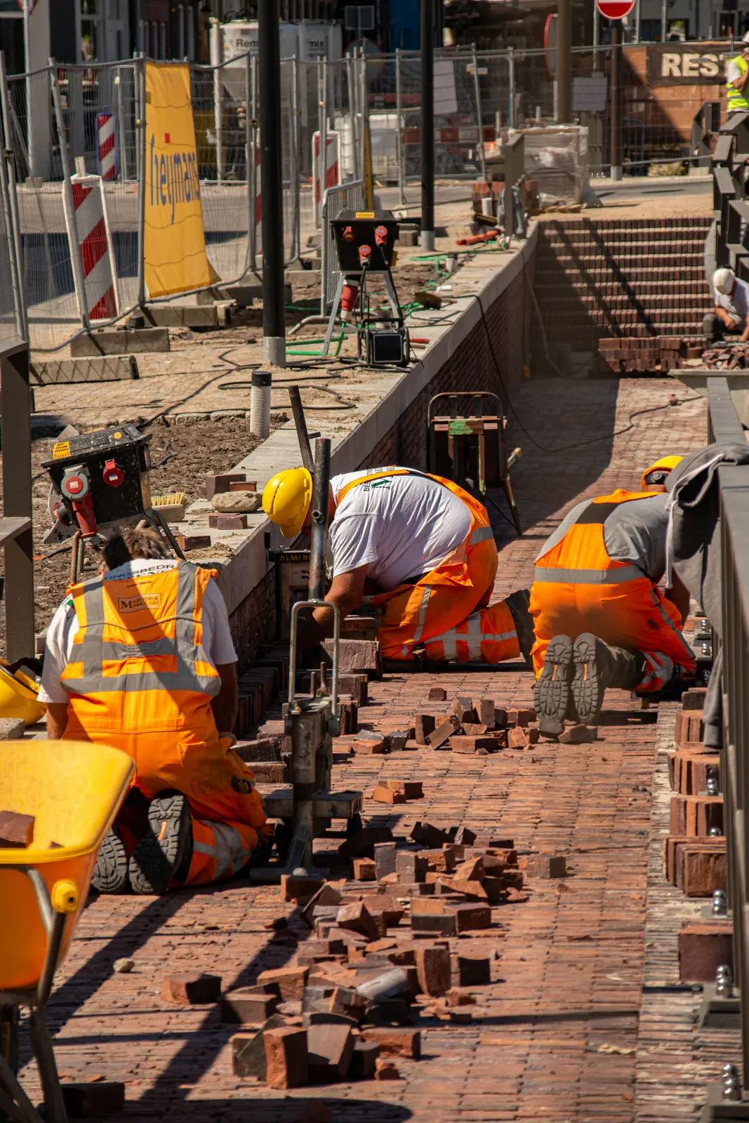 Paving contractors laying brick pavers on site